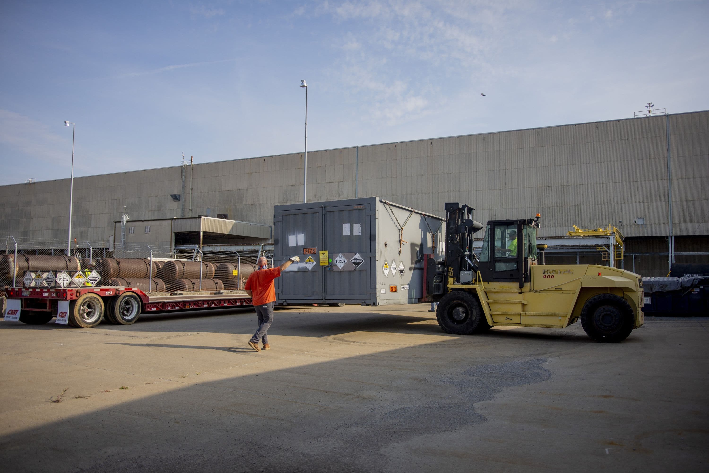 D&R contractor spots heavy equipment operator as a cold trap is lowered onto a shipping trailer outside of the storage facility.